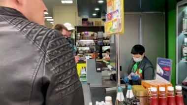 Voronezh, Rusya, 29 Nisan 2020: tıbbi maske takan kasiyer ve eldiven gişenin arkasında duruyor. Kendini hastalıklardan koruyan ve müşterilere güvenle hizmet eden bir kadın. Tehdit kavramı