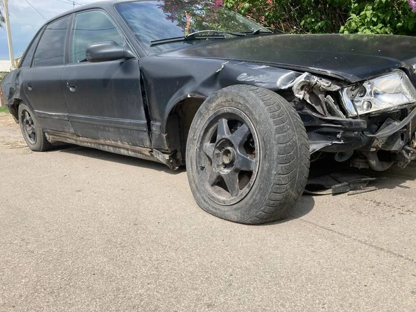 De auto na het ongeluk. Gebroken auto op de weg. Het lichaam van de auto is beschadigd als gevolg van een ongeval. Hoge snelheid hoofd bij een auto-ongeluk. Dents op de carrosserie na een botsing op de — Stockfoto