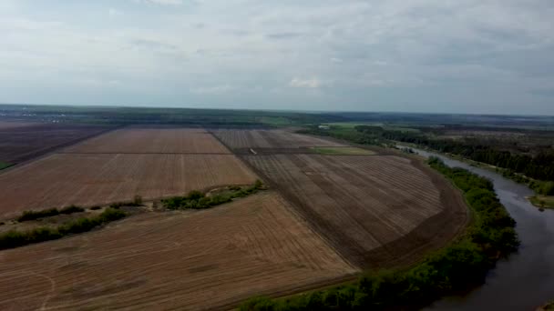 Aerial view of lake in countryside on cloudy day. Birds eye view of lake stretches in length in rural area. — Stock Video