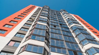 Mavi gökyüzü olan güneşli bir günde modern apartman binaları. Modern bir apartmanın ön cephesi. Modern apartman binası mimarisi