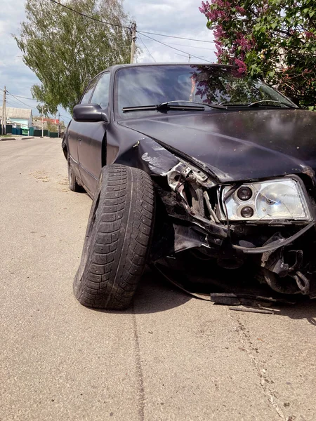 El coche después del accidente. Coche roto en la carretera. El cuerpo del coche está dañado como resultado de un accidente. Cabeza de alta velocidad en un accidente de tráfico. abolladuras en la carrocería del coche después de una colisión en el —  Fotos de Stock