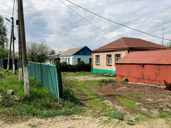 Old houses in countryside. Small one-story houses in village on cloudy day.