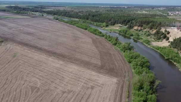 Lugn flod på landet. Från ovan, en fantastisk flod med lugnt vatten som ligger intill en vårskog i naturen. En smal, slingrande flod som rinner genom en träddunge. — Stockvideo