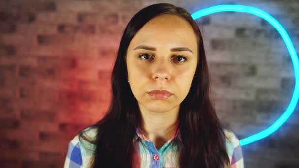 Portrait of attractive woman putting medical mask on face against illuminated wall at home. Close up of female protecting yourself from diseases. Concept of threat of coronavirus epidemic infection. — Stock Video