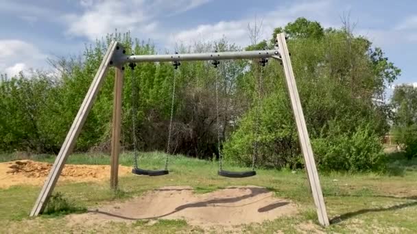 Primer plano de balanceo solitario en el campo. columpios para las personas en el fondo de árboles verdes en la aldea . — Vídeos de Stock