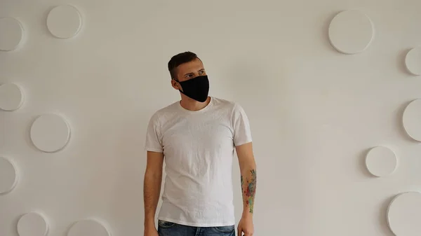 Jóképű Fiatalember Fekete Orvosi Maszkban Fehér Fal Hátterén Pózol Felnőtt — Stock Fotó