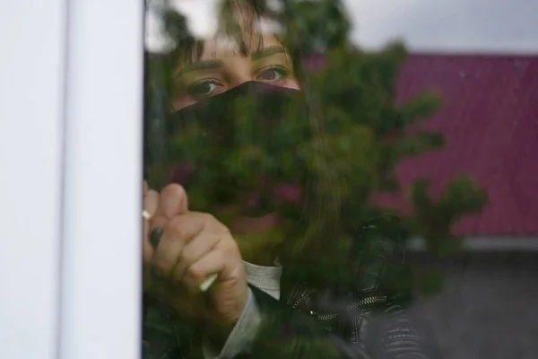 Portret Troskliwej Kobiety Brązowymi Oczami Obserwującej Przez Okno — Zdjęcie stockowe