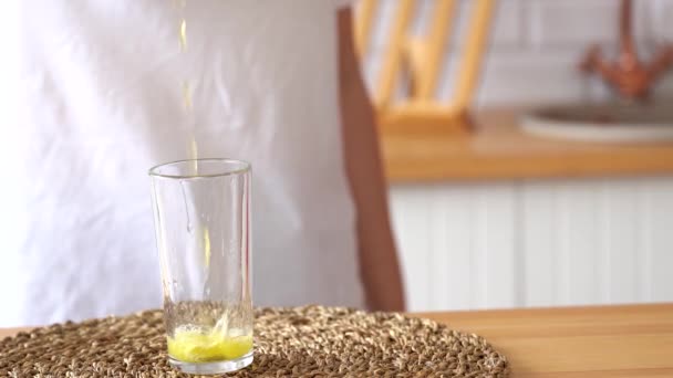 Großaufnahme Frau Gießt Küche Gelbes Sprudelndes Getränk Ins Glas — Stockvideo