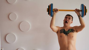 Yetişkin güçlü bir adam spor yapıyor, tüm gücünü kullanıyor..