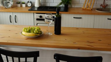 Mutfaktaki tabakta meyve tabağı olan açık şarap ve şarap şişesini kapat..