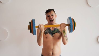 Yetişkin güçlü bir adam spor yapıyor, tüm gücünü kullanıyor..