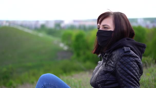 Mujer Joven Con Máscara Médica Negra Ropa Casual Sentada Colina — Vídeo de stock