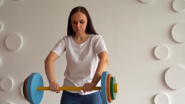 Young Woman Lifts Multicolored Barbell White Patterned Wall Adult Lady — Stock Video