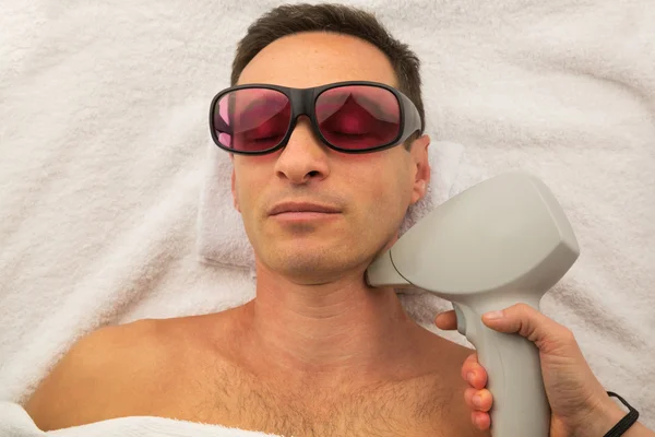 Beyaz havlu üzerinde döşeme spa salonda gözlüklü adam