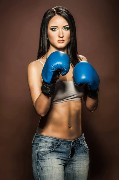 Beautiful brunette woman with blue boxing gloves — Stock Photo, Image