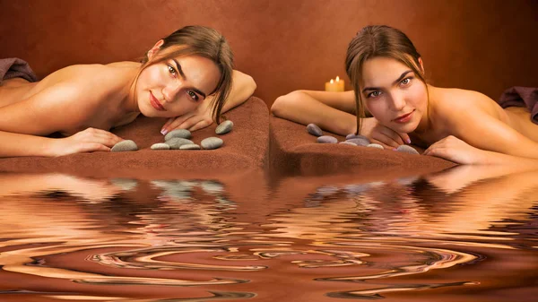 Lindas irmãs gêmeas mentirosas mulheres em um salão de spa — Fotografia de Stock