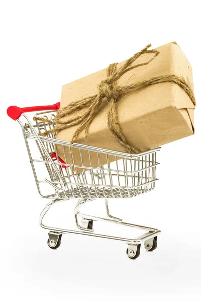 Regalo con papel de regalo y arpillera de hilo en el carrito de la compra —  Fotos de Stock