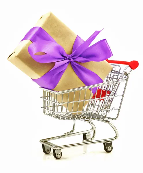 Gift with light violet ribbon in the shopping cart — Stock Photo, Image