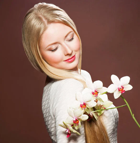 Mulher loira muito jovem com cabelo bonito e orquídea flor — Fotografia de Stock