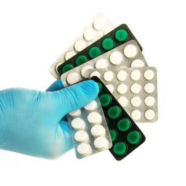 Mavi lastik eldivenli erkek el beyaz arka planda ambalajda tabletleri tutar