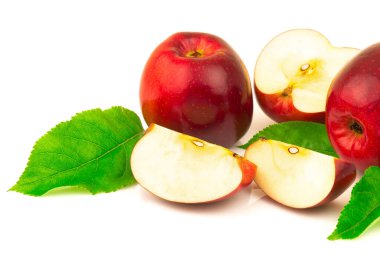 Dilimlenmiş kırmızı elma ve beyaz arkaplanda yeşil yaprakların makro görünümü