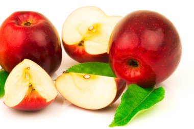 Beyaz arkaplanda yeşil yapraklı kırmızı elmanın makro görünümü