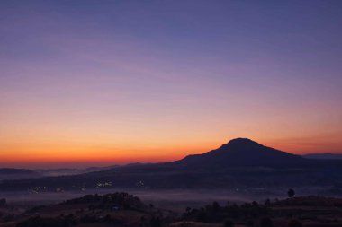 Tayland 'da Khao Takhian Ngo Phetchabun' da sisle kaplanmış dağların arkasında gün doğumu ve sabah ışığı.