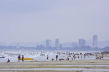 Turistler, Tayland 'daki Hua Hin Sahili' nin arka planında, Prachuap Khiri Khan 'da sahilde yürürler. 15 Mart 2020