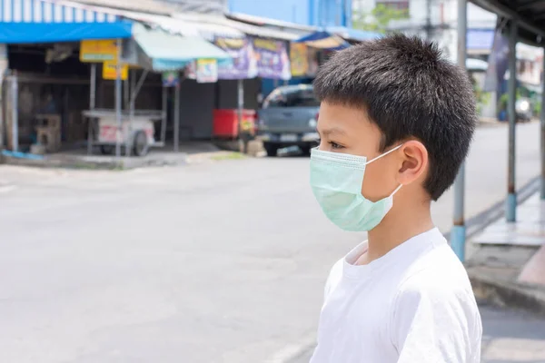 マスクをしたアジア系の少年 タイのバンコクの通りに立つ — ストック写真