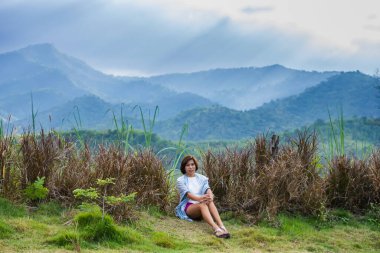 Kadın ve güneş bulutların arasından Tayland 'da Ratchaburi' nin Suan Feng 'indeki ağaçlara parlıyor..