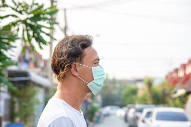 Asyalı adam Bangkok, Tayland 'da tozu önlemek için maske takıyor..
