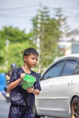 Plastik kova tutan Asyalı çocuk Songkran festivali ya da Tayland 'da yeni yıl.