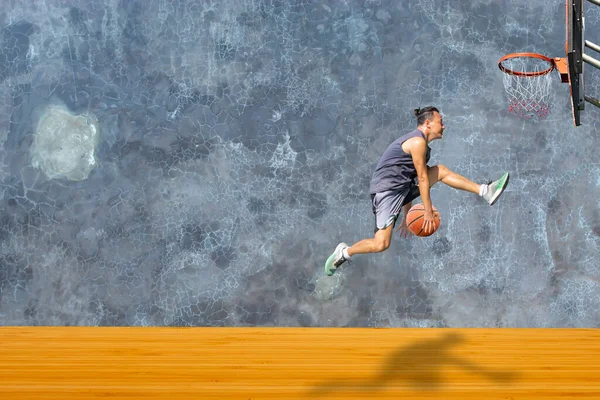 篮球手跳起来把篮筐扔在木制地板上背景墙阁楼上 上面有裂缝的图案 — 图库照片