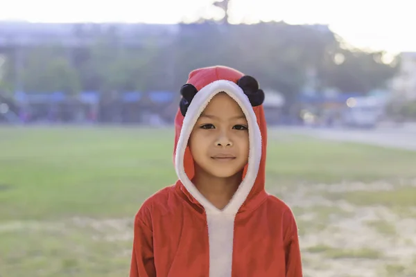 亚洲男孩穿着红色的圣诞背景在学校草坪上 — 图库照片