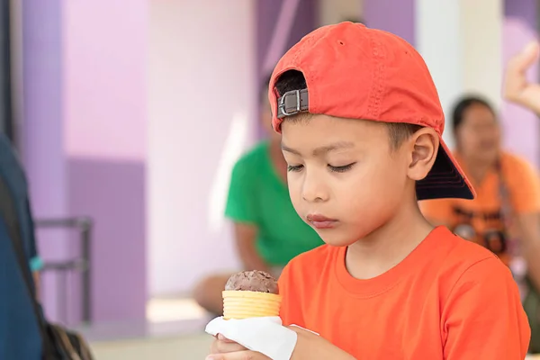 The boy holding the ice cream eating