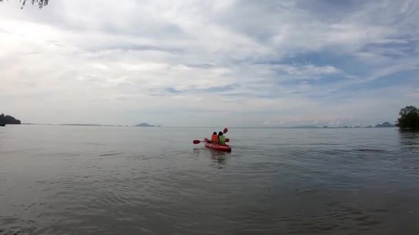 Зображення позаду "Туристів" носить рятувальні жилети, що каяються в морському фоновому дереві і хмарах у крабі, Таїланд. 15 жовтня 2020 — стокове відео
