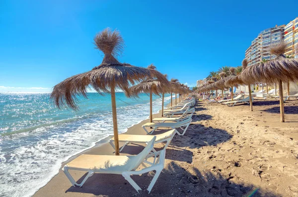 Solstolar och parasoller på stranden — Stockfoto