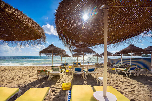 Пляж с пумбреллами и сандалиями на пляже Беналмадена

