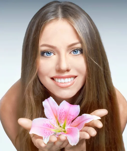 Portrait of young smiling woman with pink lily — Stock Photo, Image