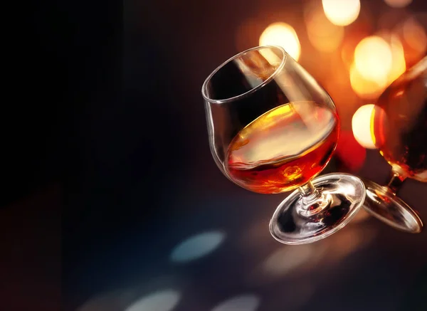Gekipptes Cognac Glas Mit Farbenfroher Heller Beleuchtung Auf Schwarzem Hintergrund — Stockfoto
