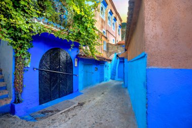 Narrow street with blue painted walls in old medina of Chefchaouen. Morocco, North Africa clipart