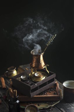 Koyu siyah arka plan Türk kahve fincanı Türk aromalı fasulye sıcak duman buharlı kahve.