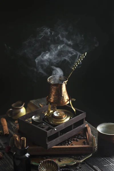 Koyu siyah arka plan Türk kahve fincanı Türk aromalı fasulye sıcak duman buharlı kahve.