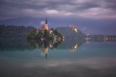 Slovenya 'nın Bled gölündeki bir adadaki bir kilisenin üzerindeki fırtına bulutları