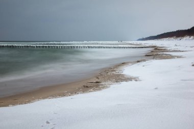 Polonya 'nın başkenti Hel yakınlarındaki Chalupy köyündeki popüler plajda donmuş dalgalar.