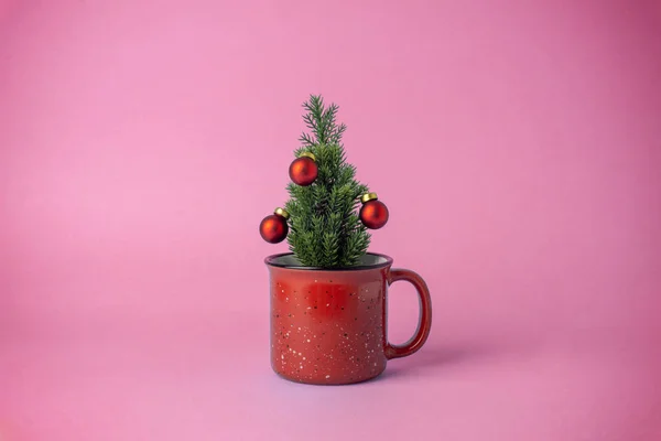 Vánoční stromeček s dekoracemi v šálku na růžovém pozadí. C — Stock fotografie