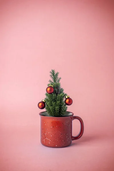 Vánoční stromeček s dekoracemi v šálku na růžovém pozadí. C — Stock fotografie