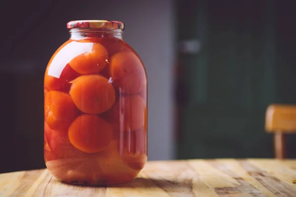 Tomates en escabeche en un adobo, en un frasco de vidrio sobre una mesa de madera —  Fotos de Stock