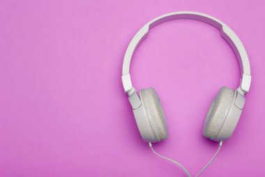 Renkli pembe arka planda müzik kulaklıkları. Estetik yeniden canlandırma