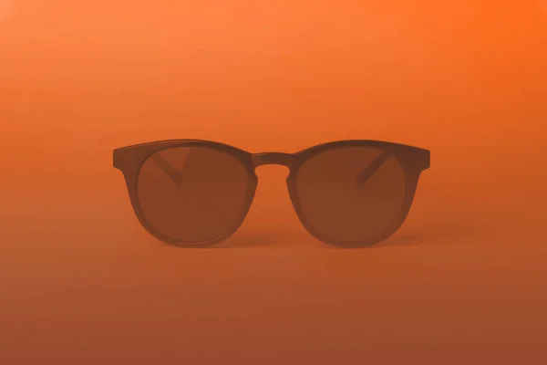 Gafas de sol vintage en iluminación naranja. Gafas de sol rosadas en mínimo —  Fotos de Stock